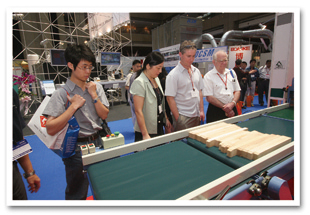 Visitors study woodworking machines at Interwood Taipei. 