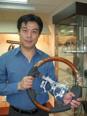 Deco Car rep demonstrates the high-end steering wheel with hand-drawn  patterns.