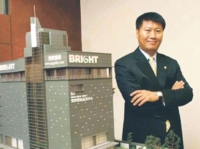Hsu and the model of his company's headquarters building.