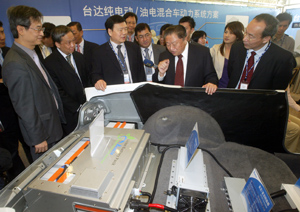 Delta chairman Bruce Cheng (right) introduces his hybrid electric vehicle propulsion system to Lo Ching-jung (second right), deputy director general of China`s Ministry of Industry and Information Technology.