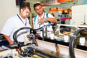 Foreign buyers view an automated Taiwan-made plastic processing machine.