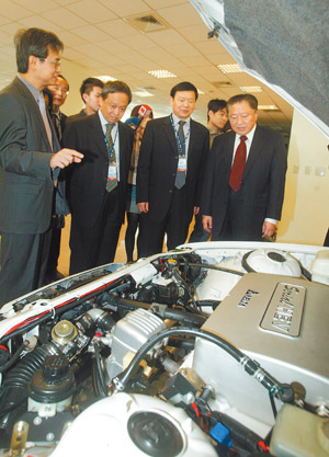 Delta chairman Bruce Cheng (right) introduces his hybrid electric vehicle propulsion system to Lo Ching-jung (second right), deputy director general of China’s Ministry of Industry and Information Technology.