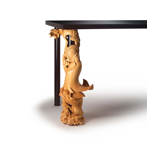 One leg of this table is carved in a religious motif.