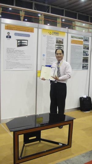 Roy Chung proudly shows off his Gold Medal-winning TV stand (front).