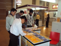 Visitors browse CENS publications at Indoautomotive. 