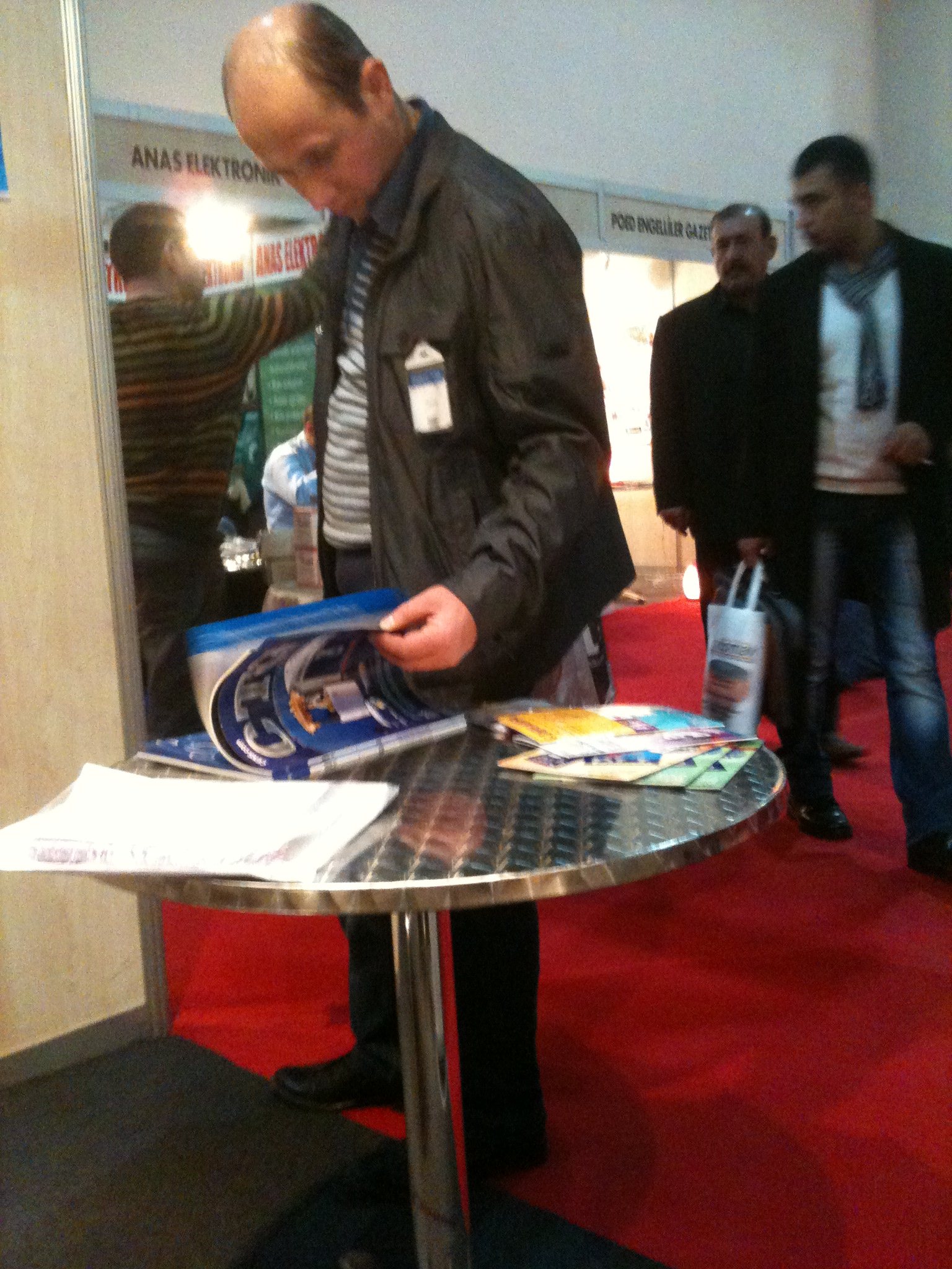 A visitor browses CENS magazine at Otomotiv. 