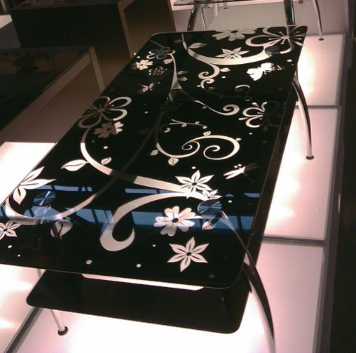 A table with black floral-patterned top is one of the best selling furniture items at the gallery. 