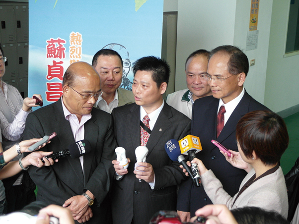 Chen (center) explains the characteristics of LVD induction lamps to former premiers Su Cheng-chang (left) and Yu Shyi-kun (right), as reporters watch.