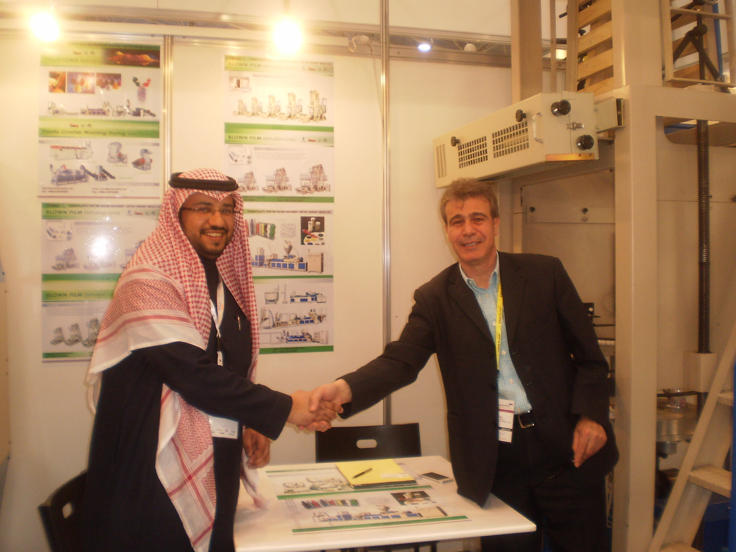 Zeyad El-Aga from the Taiwan Plastic Machinery Center Co. (right) shakes hands with a local customer after interrupting his CENS interview.