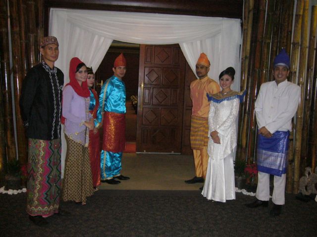 Receptionists in traditional Indonesian dress stand in front of the door, ready for the opening ceremony.