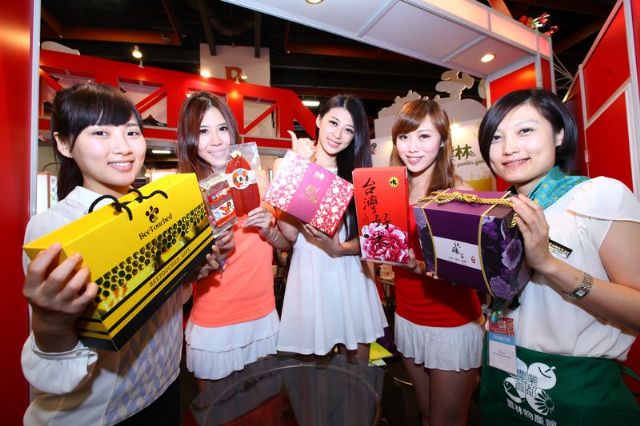 howgirls display different Taiwanese food in gift boxes.