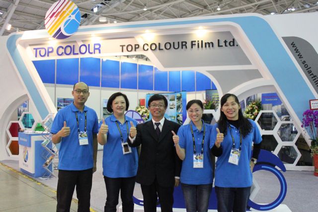 Top Colour president Robert Tsai, center, and his company staff pose in front of  his company's booth at 2014 Taipei AMPA.
