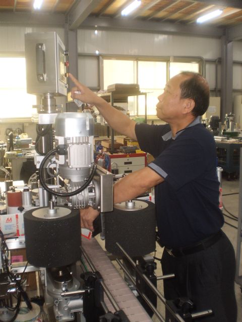 Great Gold Good’s general manager, L.H. Tsai, demonstrates a labeling machine at its new headquarters.