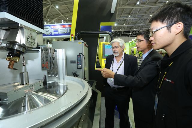 Weakened NT-dollar fattenes earnings at Taiwan's machine-tool makers in the third quarter. (Pictured are foreign buyers at a Taipei machine tool trade show.)