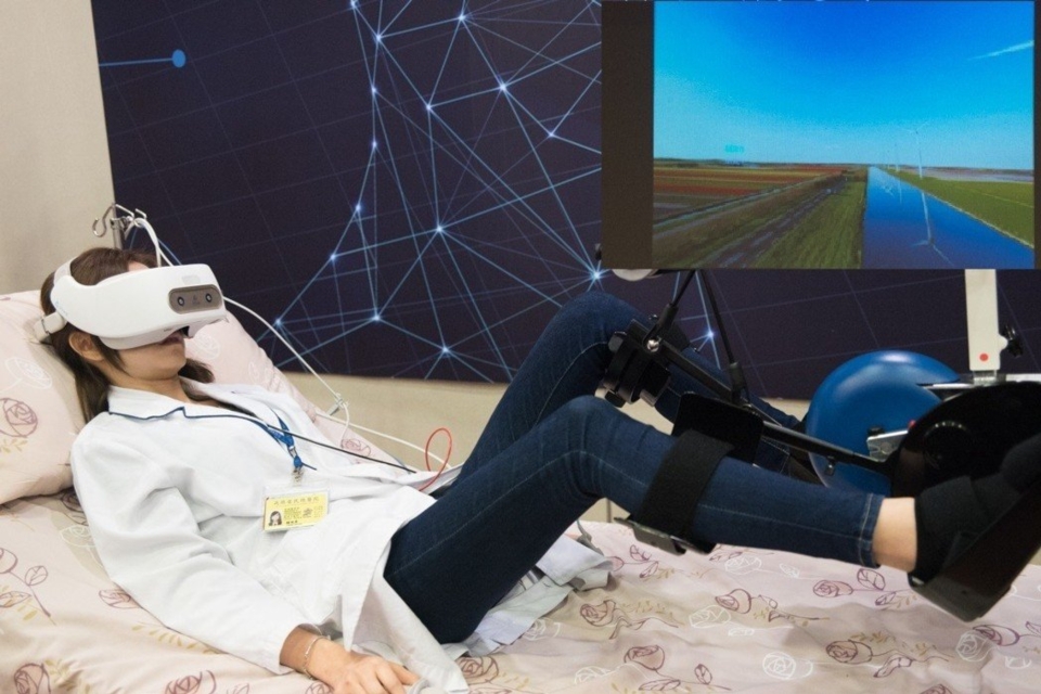 記者會上示範VR虛擬遊戲協助重症病患腿部復健。 黃啟銘/攝影、合圖。