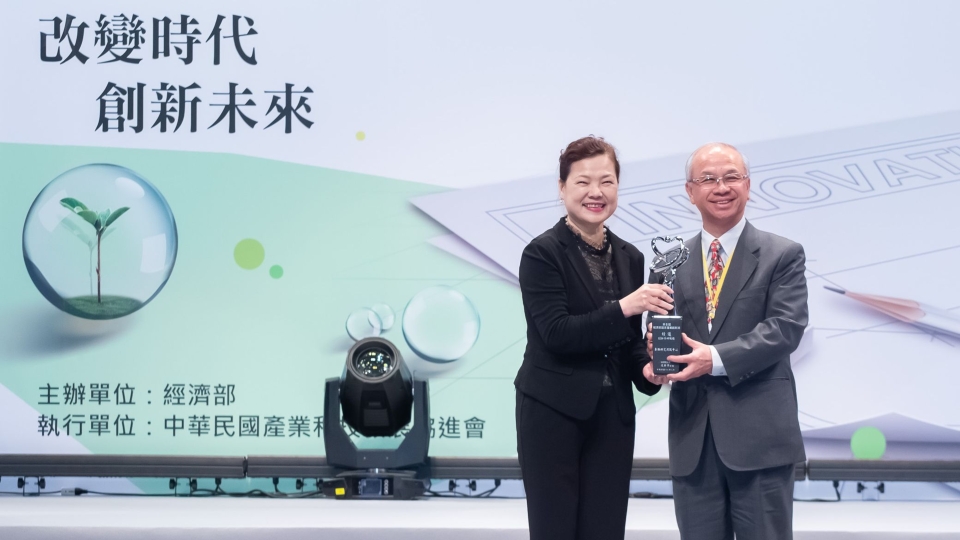 圖2：車輛中心榮獲第6屆「經濟部國家產業創新獎--績優創新學研機構」，由董事長陳昭義(右)代表接受由經濟部次長王美花(左)的頒贈。(車輛中心)