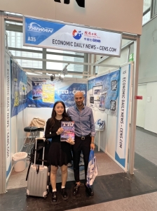 Economic Daily News (CENS) publication team member poses with a buyer at Automechanika Frankfurt, while holding the Taiwan Transporation Equipment Guide (TTG). (Photo courtesy of CENS)