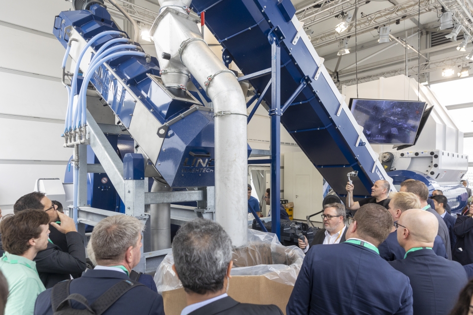 參觀者觀賞機械設備生產塑膠再生膠粒的過程。（圖/Messe Düsseldorf GmbH）