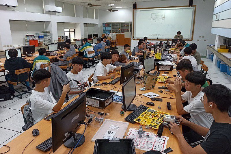 機械人組裝操作實作實習課堂上，講師指導學生組裝機器人、編寫程式。 教育部／提供